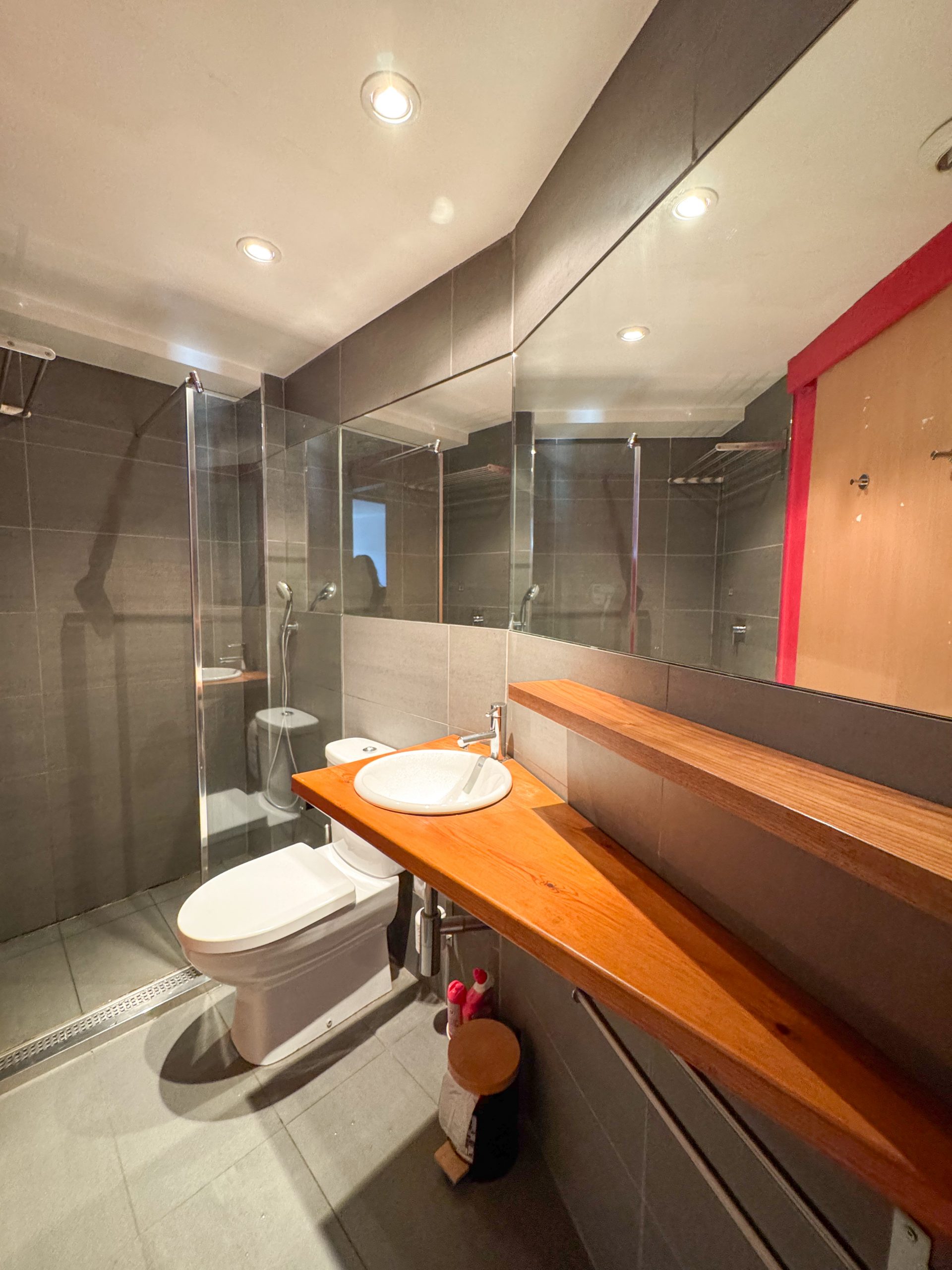 Salle de bain moderne avec douche, lavabo et rangements dans un appartement de l’Appart'hôtel Cerdanya.