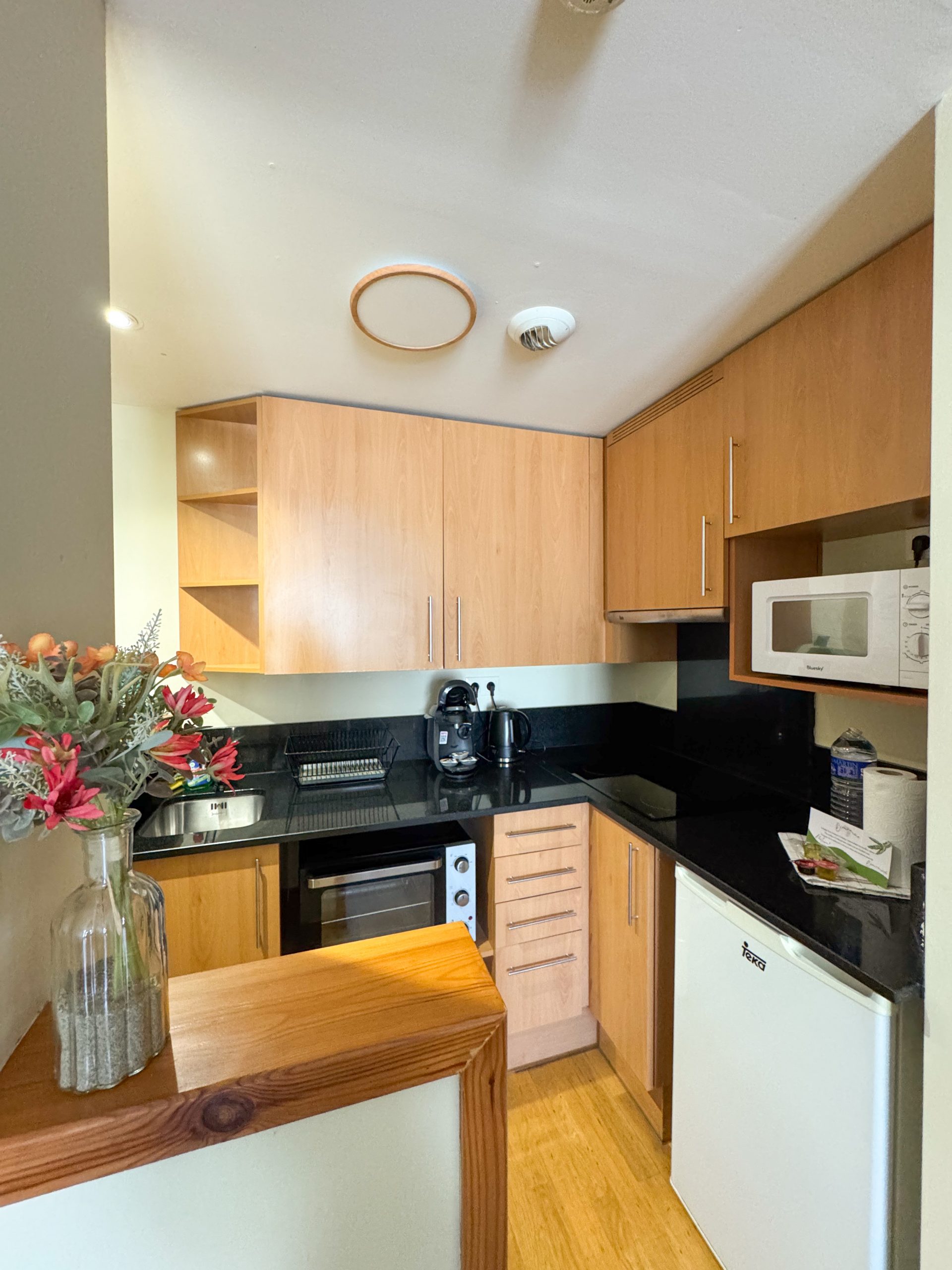 Cuisine moderne entièrement équipée avec plaques, four, micro-ondes, réfrigérateur et rangements dans un appartement de l’Appart'hôtel Cerdanya.